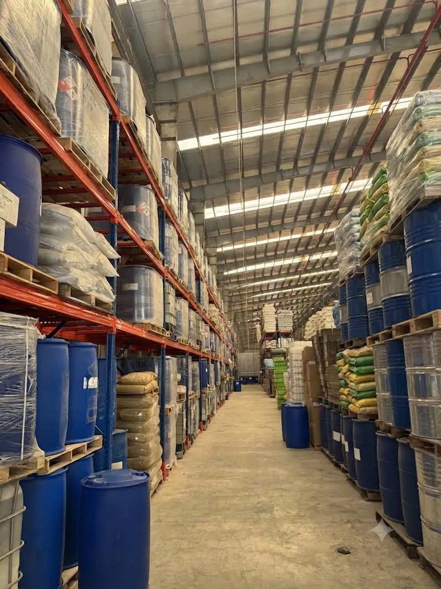 Kho hàng PT-GrowChem tại Củ Chi, TP.HCM — phuy, can và bao nguyên liệu xếp trên kệ